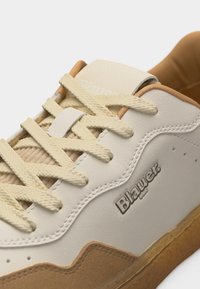 Αθλητικό παπούτσι Blauer σε κρεμ και ταμπά αποχρώσεις με υφασμένες κορδόνια, ραφές και λαστιχένια σόλα, σε κοντινή γωνιακή λήψη.