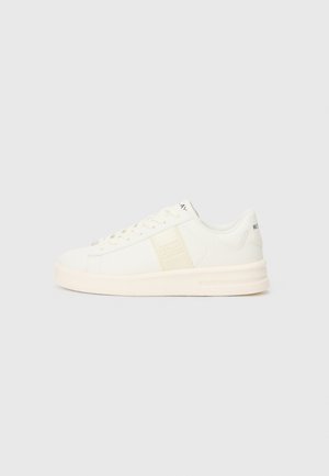 Białe sneakersy z gładkiej skórzanej cholewki, okrągłym noskiem, płaskimi sznurowadłami i cienką, wyściełaną podeszwą. Posiadają wytłoczone logo po bokach.