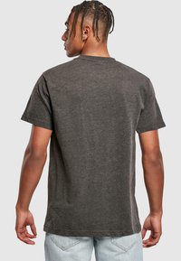 Mørkegrå bomulds T-shirt med korte ærmer, rund hals og en afslappet pasform, der viser en glat tekstur og et simpelt design.