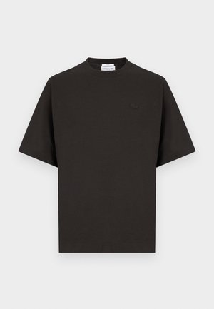 T-shirt nera a maniche corte con scollo rotondo, piccolo logo coccodrillo Lacoste tono su tono sul petto a sinistra e orlo dritto.