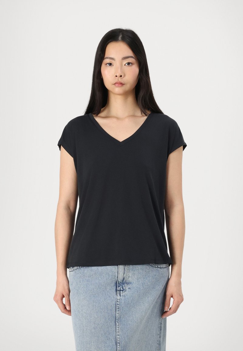 Tricou negru, cu mânecă scurtă și guler în V, confecționat dintr-un material moale, asortat cu o fustă din denim albastru deschis. Design simplu, croi drept, fără modele vizibile.