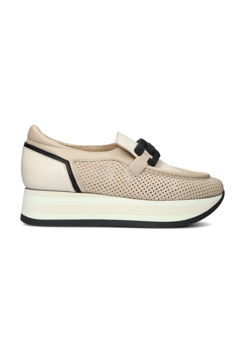 Beige sneaker met een geperforeerde leren bovenkant, zwarte accenten en een prominente strap. Heeft een dikke wit- en zwartkleurige zool voor extra hoogte.