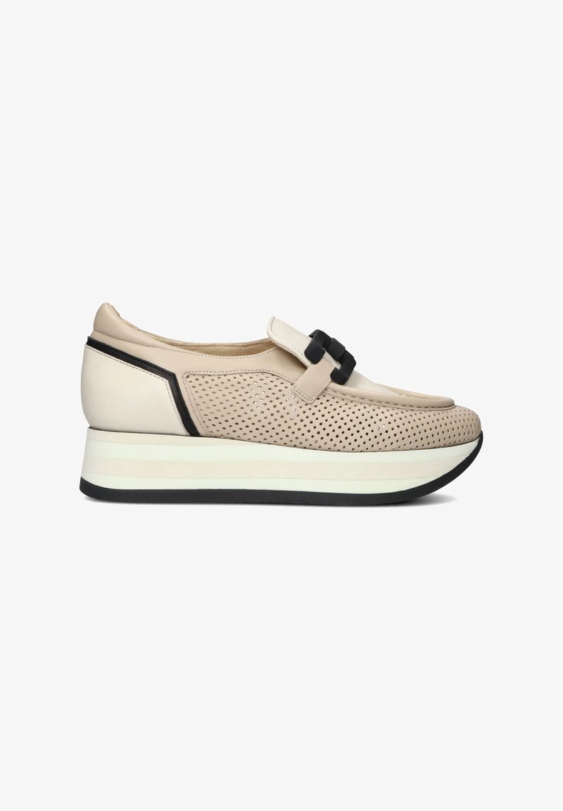 Beige sneaker met een geperforeerde leren bovenkant, zwarte accenten en een prominente strap. Heeft een dikke wit- en zwartkleurige zool voor extra hoogte.