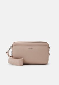 Borsa a tracolla rosa chiaro in materiale sintetico liscio, con chiusura a zip e tracolla regolabile. Presenta il logo in rilievo sulla parte anteriore.