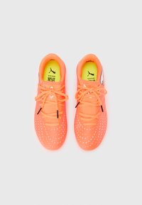 Φωτεινά πορτοκαλί αθλητικά παπούτσια με υφή διχτυωτού επάνω μέρους, κορδόνια σε όμοιο χρώμα και ένθετο πάτο σε νέον κίτρινο. Διαθέτουν μικρά λευκά σχέδια με τελείες και λογότυπο.