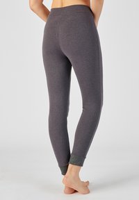 Leggings grises con una textura suave, diseño ajustado y un acento metálico en los puños de los tobillos. Cintura acanalada para mayor comodidad.