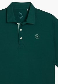 Mörkgrön polo-skjorta med krage, med en subtil logotyp på bröstet och tre knappar längs knäppningen.