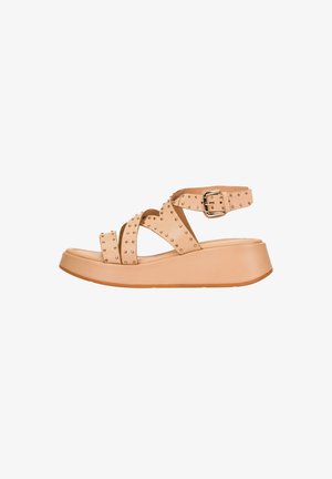 Sandalia de plataforma beige con tiras cruzadas adornadas con tachuelas, hebilla ajustable en el tobillo y suela gruesa, sobre fondo blanco.