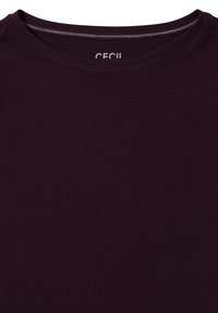 Dunkellila T-Shirt mit Rundhalsausschnitt, aus einem weichen, glatten Stoff gefertigt. Verfügt über ein kleines Logo am Hals. Einfaches, einfarbiges Design.