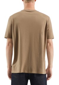 T-shirt marron à manches courtes avec col rond, fabriqué en tissu de coton lisse. Design simple sans logos ni motifs visibles.