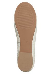White rubber shoe sole featuring a textured surface with horizontal and vertical ridges, and a smooth beige section at the heel.
