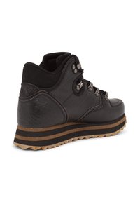 Zapatillas altas de cuero negro con paneles texturizados, detalles de metal y suela de goma con franjas horizontales y un diseño de banda robusto.