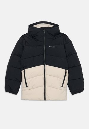Veste matelassée avec une partie supérieure noire et une partie inférieure beige. Elle possède une capuche, une fermeture éclair à l'avant et deux poches latérales zippées.
