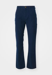 Navy blue pants made from cotton twill with a flared design, featuring a front button closure and side pockets. Smooth texture.