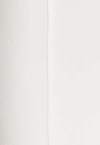 Biała tkanina o gładkiej teksturze i minimalnym połysku, z pionowym szwem. Brak widocznych wzorów lub metalowych elementów.