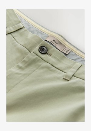 Svetlozeleni ravni hlače s temnim gumbom, ki imajo ravne sprednje žepke in gladko teksturo. Oznaka prikazuje ime blagovne znamke in velikost.