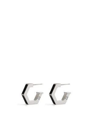 Silver geometric hoop earrings featuring a hexagonal shape, polished metal finish, and a slim black accent on the edges.