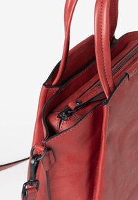 Borsa a tracolla in pelle rossa con una texture liscia, caratterizzata da una chiusura a zip, una tracolla regolabile e dettagli in metallo nero.