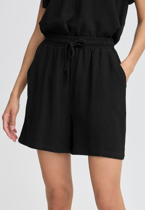 Black cotton blend shorts with an elastic waistband and drawstring, featuring side pockets and a relaxed fit. Smooth texture, mid-thigh length.