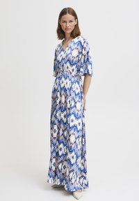 Robe maxi avec un décolleté en V et des manches courtes, présentant un motif abstrait bleu, blanc et pêche. Fabriquée en tissu léger et fluide.