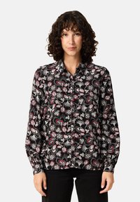 Svart knapp-up skjorta med ett paisley-mönster i vitt och rött. Långa ärmar med knäppta manschetter, klassisk krage och mjuk tygstruktur.