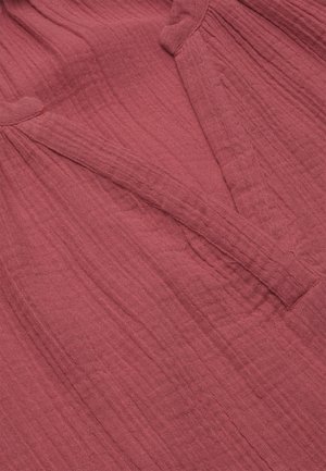 Langærmet strikket top i støvet rosa farve med tekstureret, ribbet stof og samlet detalje nær halsudskæringen.