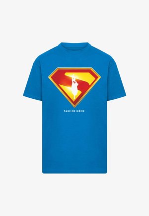 Blå bomulds T-shirt med et stort rødt og gult Superman-emblem med en hvid silhuet og teksten "TAG MIG HJEM" nedenfor.