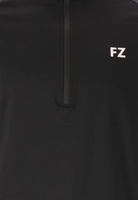 Svart halvdraget topp gjort av slät tyg, med en liten vit "FZ"-logotyp på vänster sida och en texturerad krage för extra detaljer.