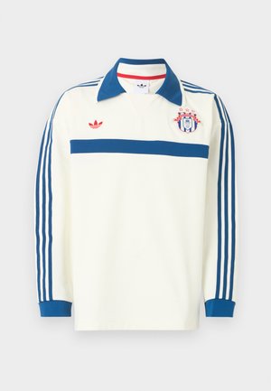 Weißes langärmeliges Sporttrikot mit blauem Kragen, blauen Streifen an den Ärmeln, blauem Bruststreifen, rotem Logo und einem Wappenschild mit Sternen auf der Brust.