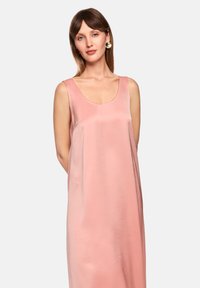 Satinkleid in sanftem Rosa mit rundem Ausschnitt und ärmellosem Design, das eine fließende Silhouette und einen dezenten Glanz aufweist.