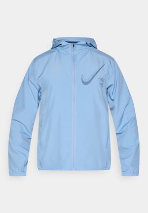 Ανοιχτό μπλε σακάκι Nike με κουκούλα, φερμουάρ μπροστά, μακριά μανίκια και μεγάλο λογότυπο swoosh στο αριστερό στήθος. Λεπτό, ελαφρύ ύφασμα.