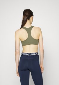 Nike Performance BRA - Sutiã desportivo de suporte médio - medium olive/white