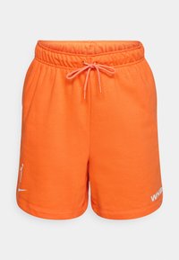 Oransje bomullsshorts med elastisk midje og snor. Har en logo på venstre ben i hvitt. Glatt tekstur og avslappet design.
