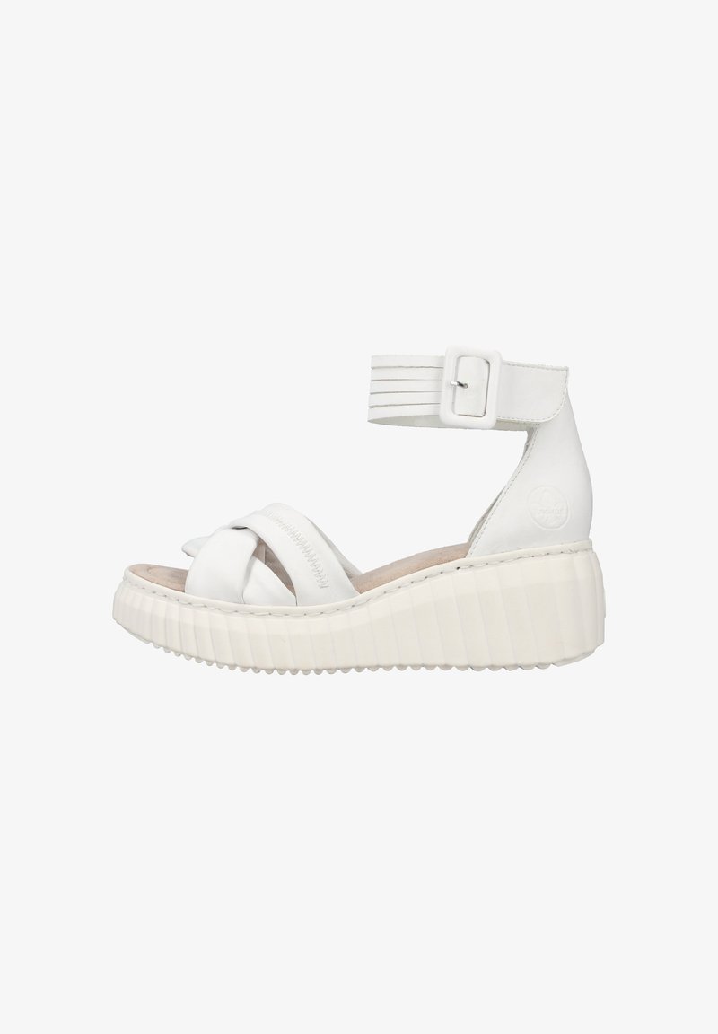 Sandales compensées blanches avec des straps croisées, une bride à boucle à la cheville et une semelle texturée. Le matériau semble lisse et semblable à du cuir.