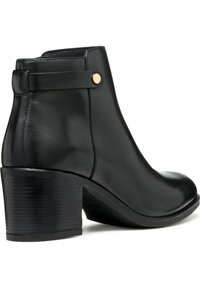 Botte cheville en cuir noir avec un bout rond, une sangle latérale avec un détail de bouton doré, et un talon texturé noir. Fini lisse.
