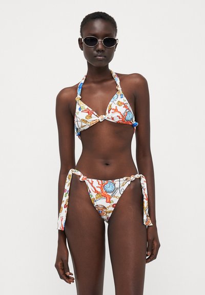 Set de bikini cu un imprimeu cu tematică maritimă în alb, având accente albastre, portocalii și aurii. Bustieră halter cu legături și un slip cu talie joasă.