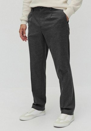 Pantalons gris charbon à coupe décontractée avec plis avant. Fabriqués dans un tissu doux, ils présentent des poches latérales et un design à front plat.