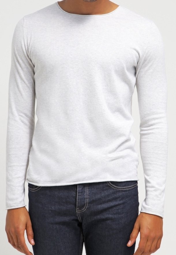 Långärmad ljusgrå bomullst-shirt med rund halsringning och figurnära passform, kombinerad med mörka jeans. Mjuk textur, minimalistisk design.