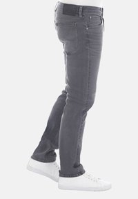 Jeans skinny grigi con una finitura sbiadita, dotati di cinque tasche, passanti per cintura e una patch in pelle nera sul punto vita.