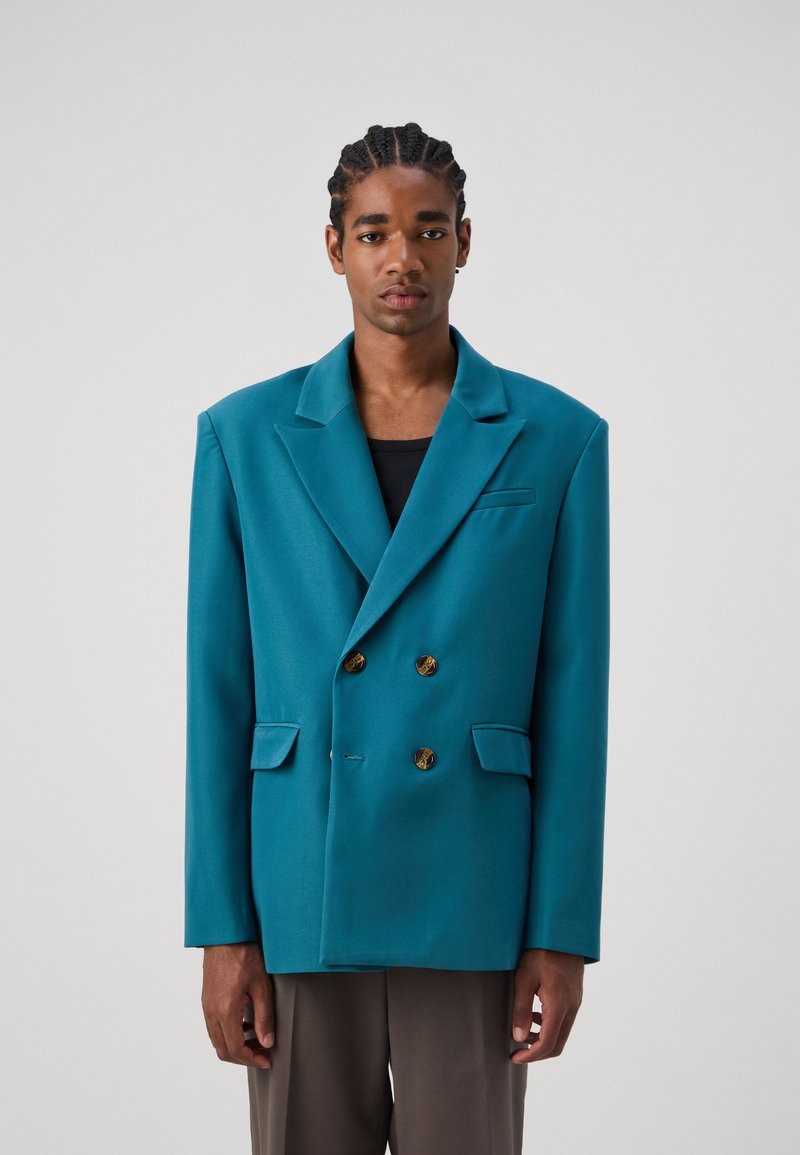 Tealfarbener oversized, doppelt geknöpfter Blazer mit goldenen Knöpfen, eingekerbten Revers und zwei Fronttaschen. Glatte Oberfläche, entspannte Silhouette.