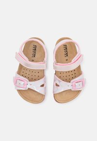 Ροζ σανδάλια με επάνω μέρος από συνθετικό δέρμα, χαρακτηριστικά σχέδια καρδιών, ρυθμιζόμενες στήριγες με αγκράφες και μαλακή σόλα.