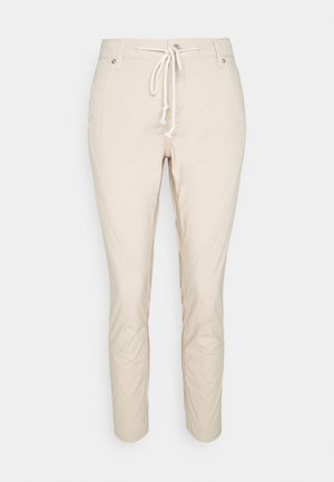 Béžové slim-fit kalhoty s předními kapsami a bílým stahováním v pase, vystavené na čistém bílém pozadí.
