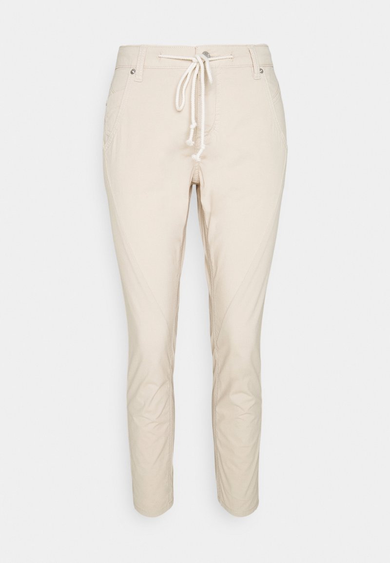 Béžové slim-fit kalhoty s předními kapsami a bílým stahováním v pase, vystavené na čistém bílém pozadí.