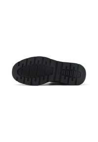 Suela de zapato de goma negra con patrones de textura para mayor agarre. Presenta una punta redondeada y el nombre de la marca "ALDO" estampado en el lateral.