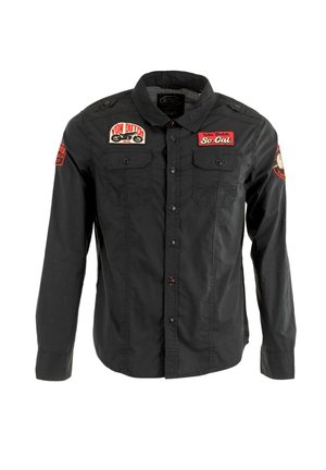 Chemise noire à manches longues avec deux poches sur la poitrine et des patchs brodés rouges portant les accents "Von Dutch" et "So. Cal.".