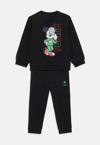 Survêtement noir en deux pièces avec un grand graphique de Mickey Mouse sur le haut, accompagné du texte "Adidas" en lettres colorées.