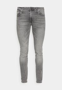 Jeans de mezclilla gris de corte slim, con bolsillos delanteros, cierre de botón y un ligero desvanecimiento en los muslos y las rodillas.
