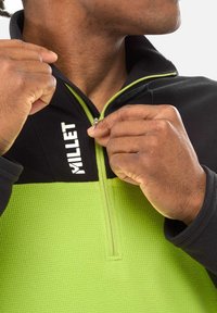 Black and lime green fleece pullover with a half-zip design. Textured fabric, prominent logo on the chest, and contrasting collar color.