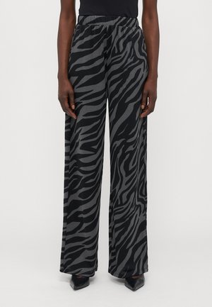 Pantalons larges noirs avec un motif rayé gris zèbre, dotés d'une taille élastique et d'une texture douce et lisse.