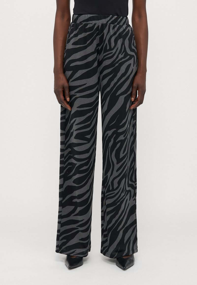 Pantaloni neri a gamba larga con un motivo a strisce zebrate grigie, dotati di cintura elastica e una texture morbida e liscia.